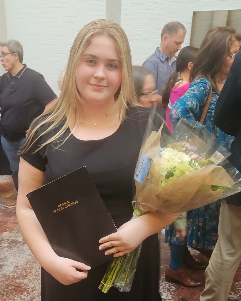Photo of Hunter Wilson holding flowers and an Honor Chorus black folder