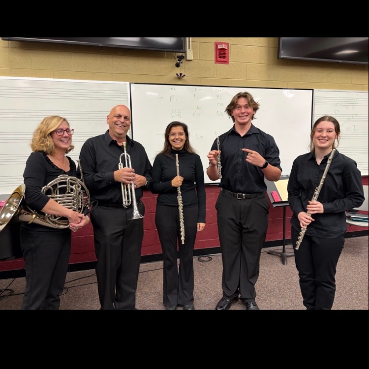 TMS Director S Farnham holding a French horn, parent Steve Gardner holding a trumpet, WHS Director Rose Diaz holding a flute, Trent Mills holding a piccolo, and Abigail McMahon holding a flute