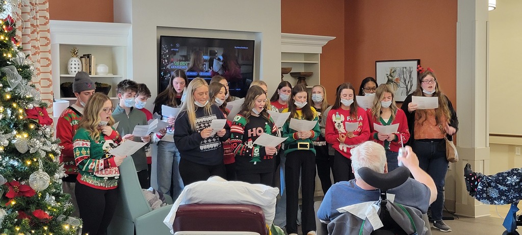 Leadership class from Southern Alamance High holding sheet music and singing carols in front of residents at Twin Lakes