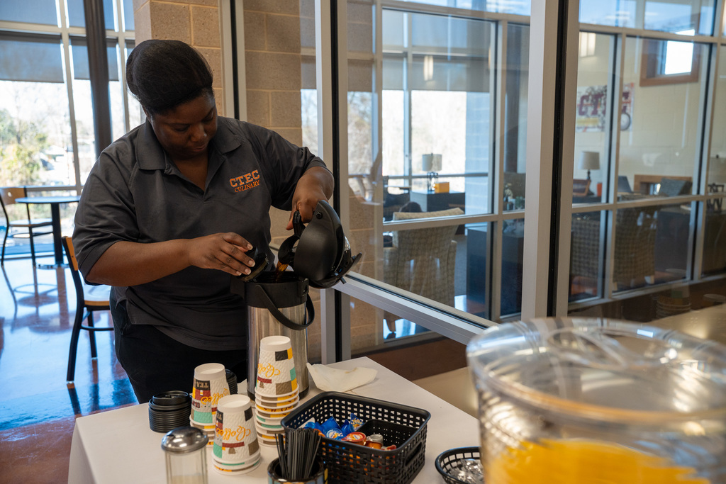 A staff member from the CTEC Culinary class pours coffee into a serving pot