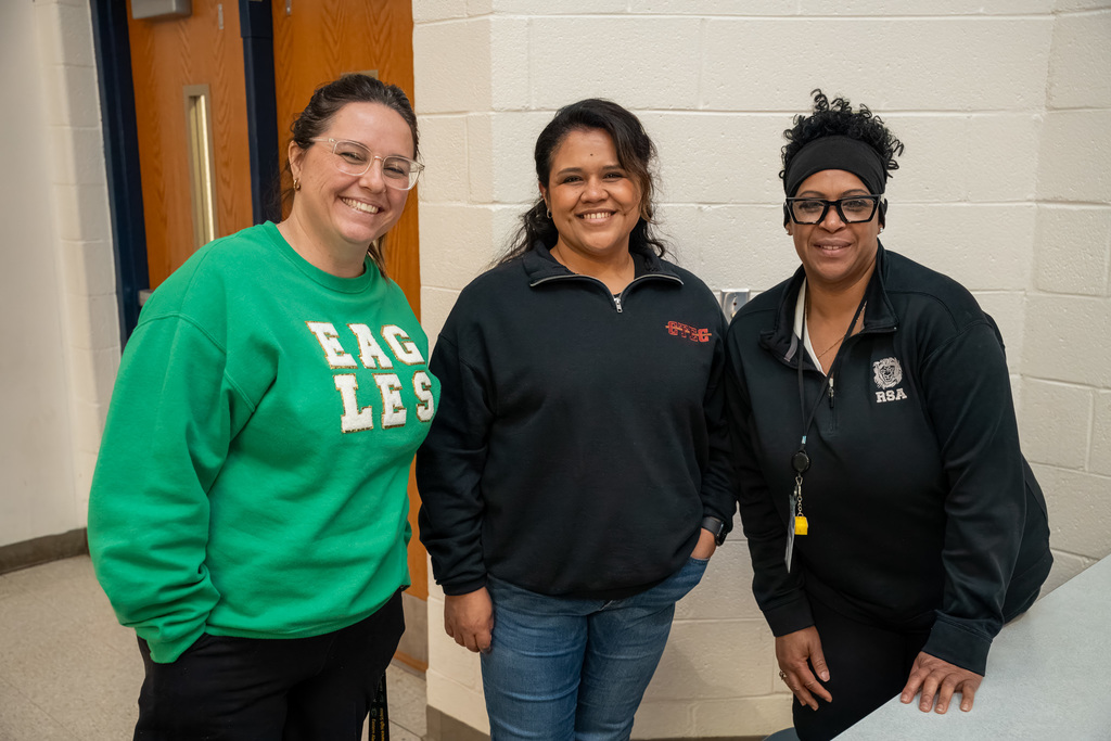 Three admin staff smile at a professional development session