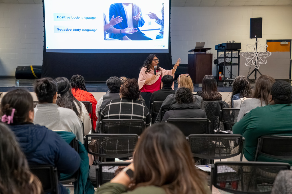 A presenter from K12 Insights gestures towards the audience at a professional development for office staff