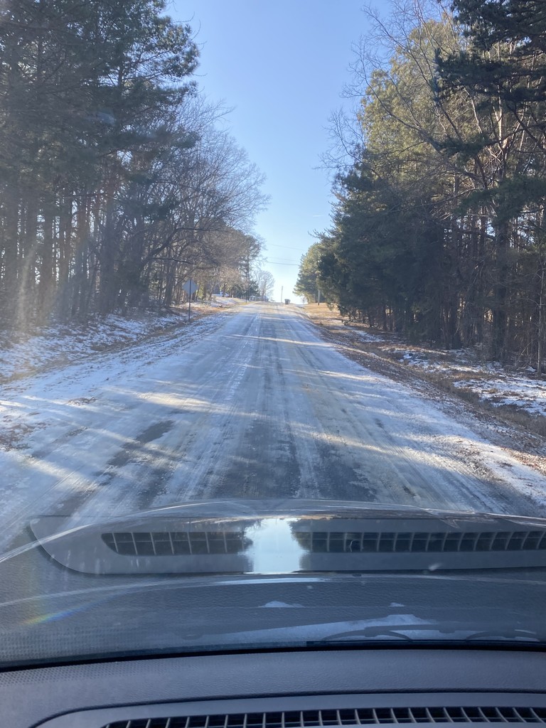 An icy road from the perspective of inside the car looking out the windshield