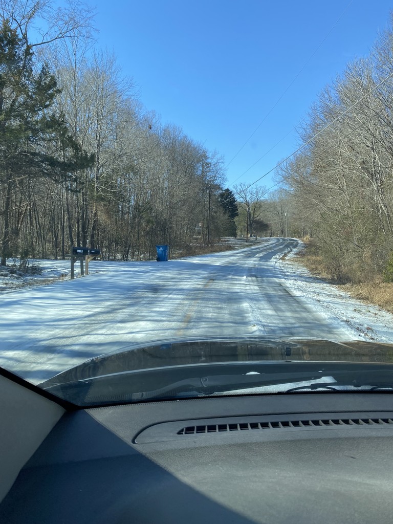 An icy road from the perspective of inside the car looking out the windshield