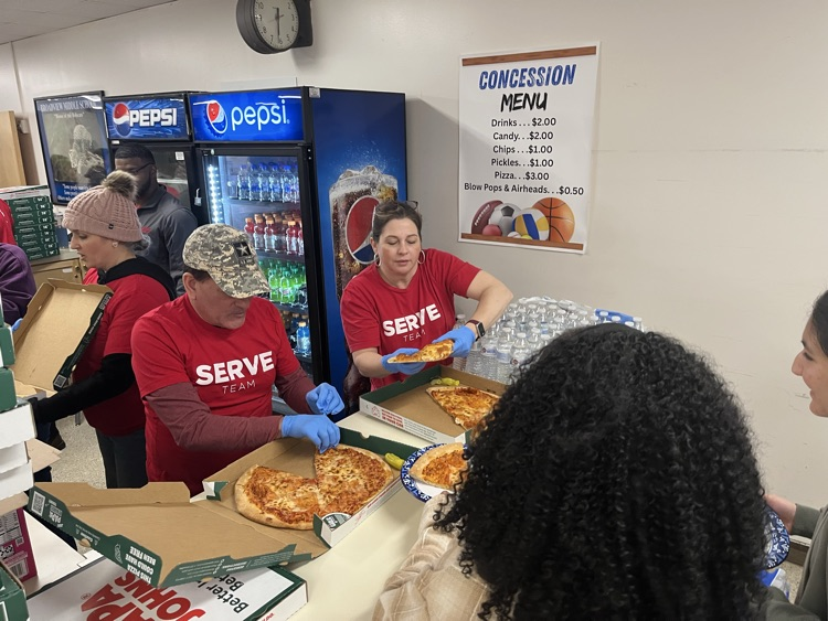 A group of community leaders serving a Papa John’s pizza lunch 