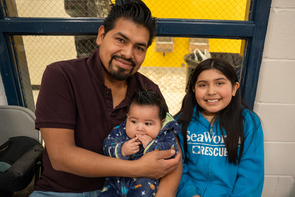 A parent with their children, one baby and one student, at lunch