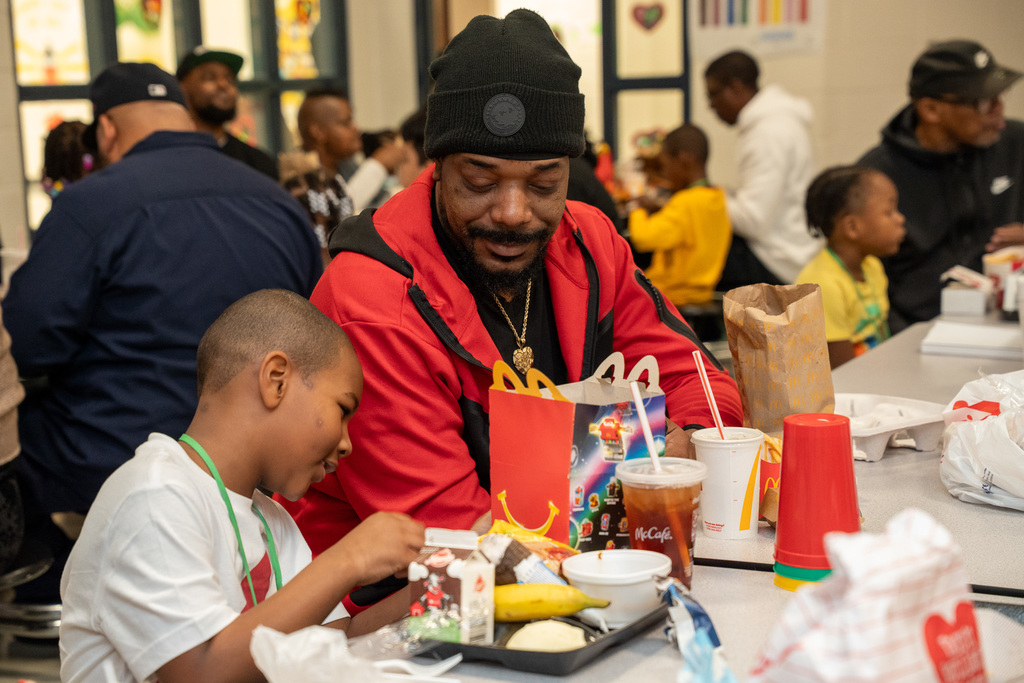 A parent eats with their child in the cafeteria at Hillcrest