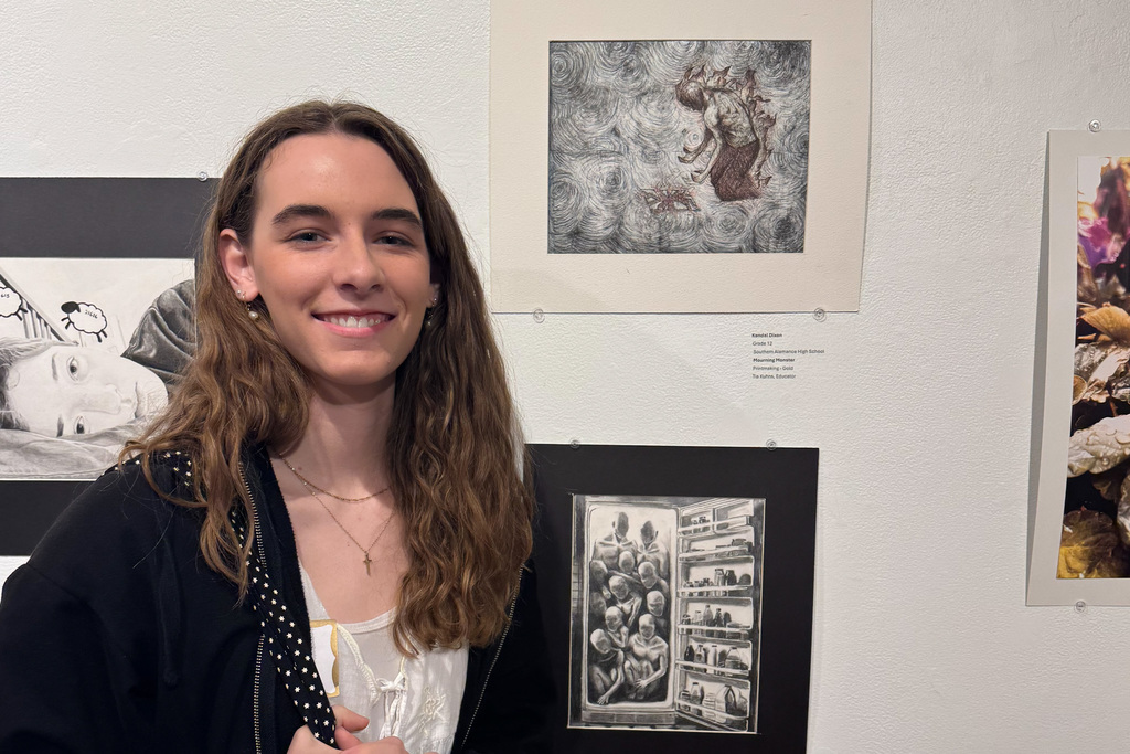 Kendall Dixon standing in front of her exhibited art