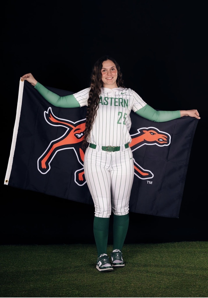 Kayden wearing an Eastern softball jersey and holding a Campbell university flag behind her
