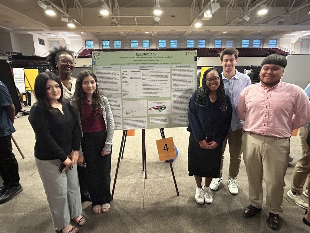 A group of six Williams High students standing beside their research project