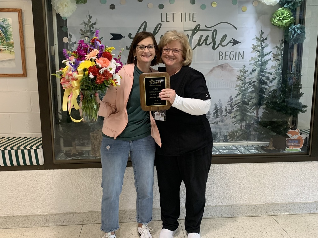 Nurse Donna Apple with flowers and plaque standing next to previous Nurse of the Year Nurse Babb