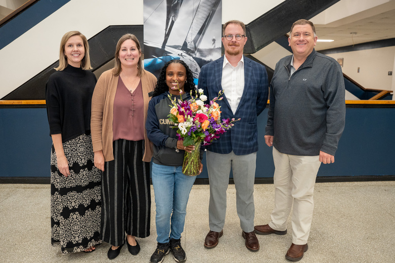 Jasmine standing with district EC staff and the Superintendent