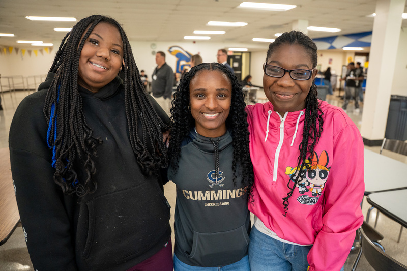 Jasmine standing with two students