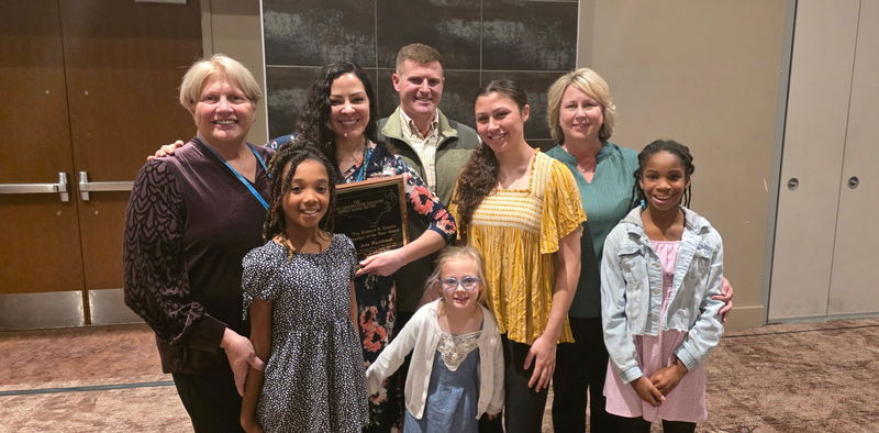 A group photo of Aria Westbrook with family and influential colleagues at the NCMEA conference