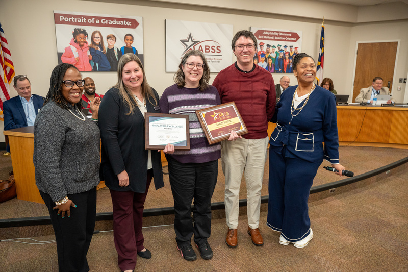 Sarah Smith standing with Eastlawn staff, Exceptional Children Executive Director Christina Armfeld, and husband