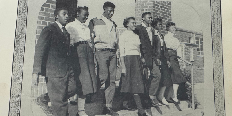 A historic photo of students at Graham High School (current Ray Street) walking down the stairs with the caption Junior Class Officers