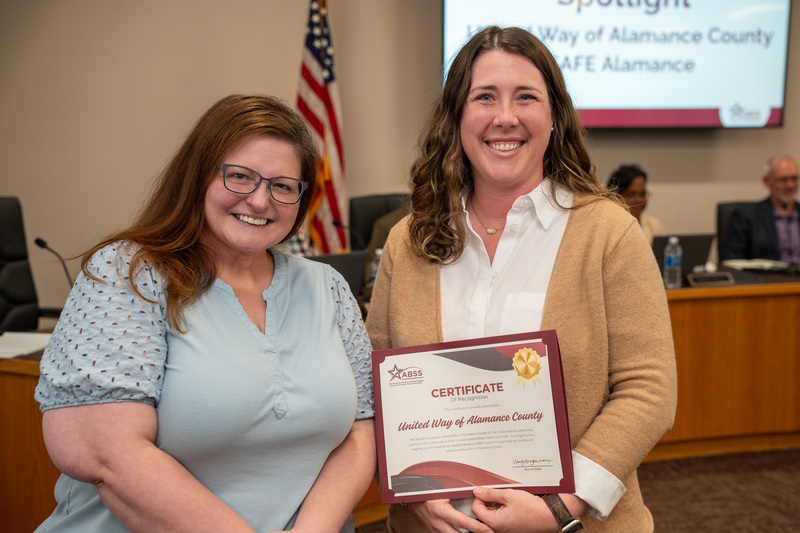 SAFE and United Way representatives smiling with a recognition certificate