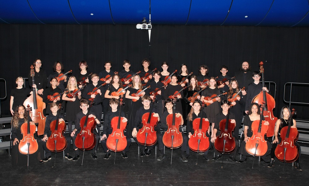 Junior School Chamber Orchestra students pose with instruments and directors