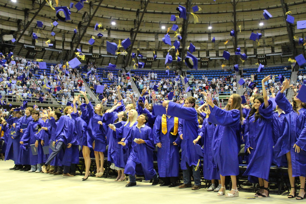 Graduates toss caps in the air 