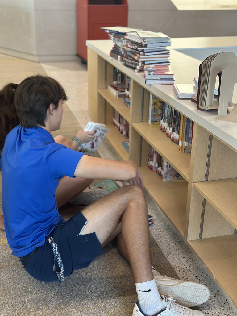 Students putting books on shelves in the library