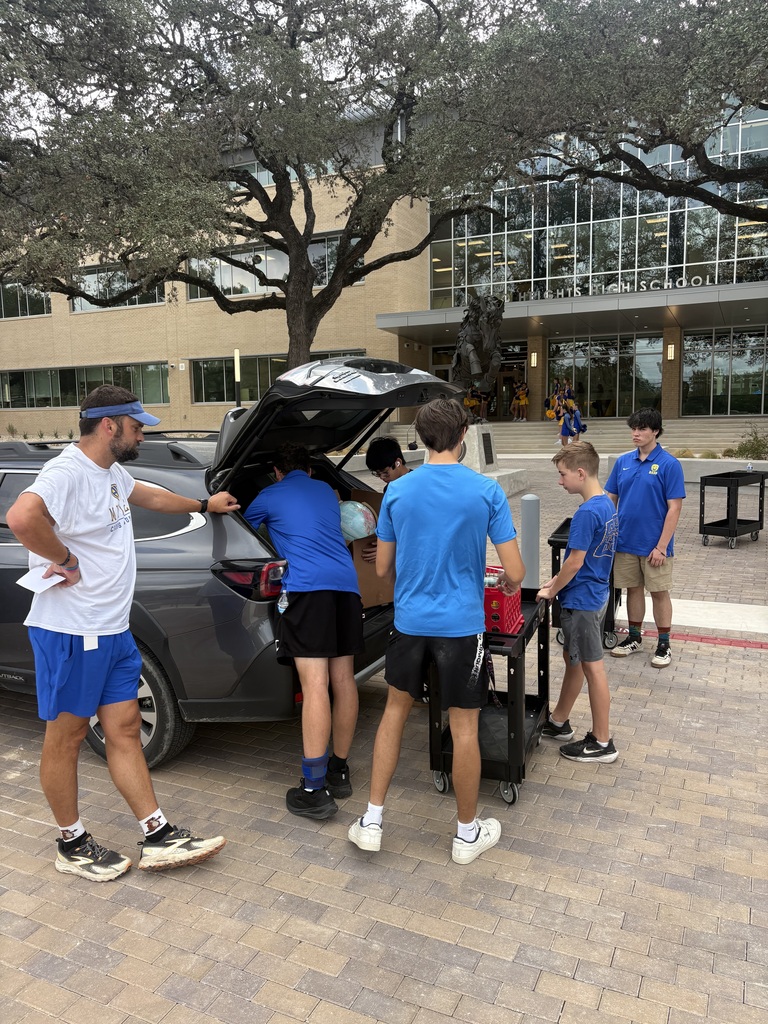 Students help teachers unload his car in front of school