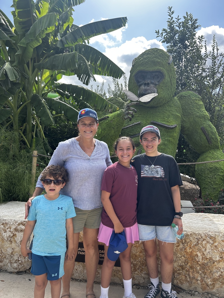 Librarian and three students pose in front of gorilla topiary 