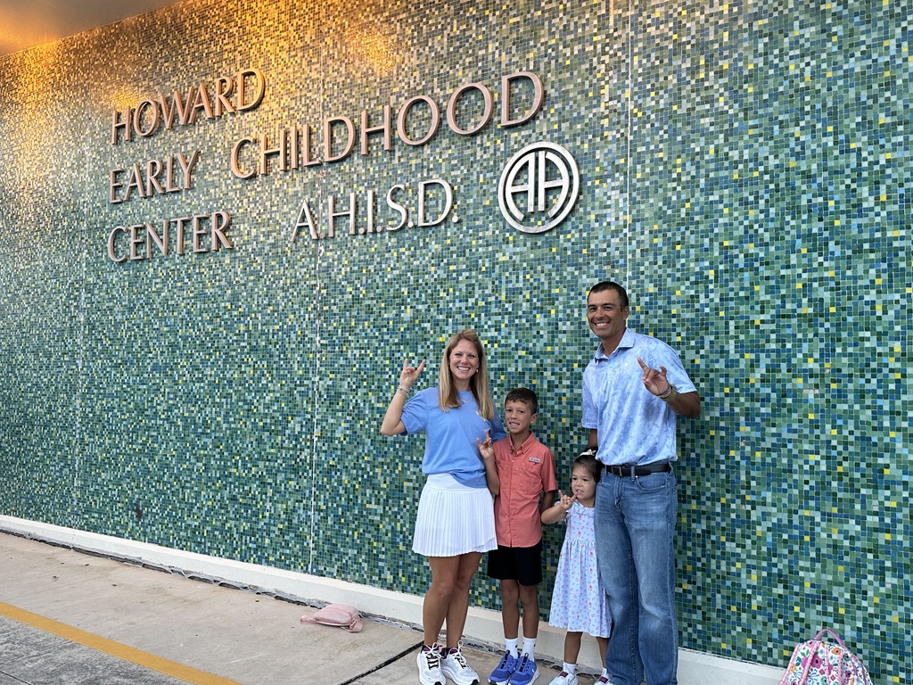 Family poses outside school on first day