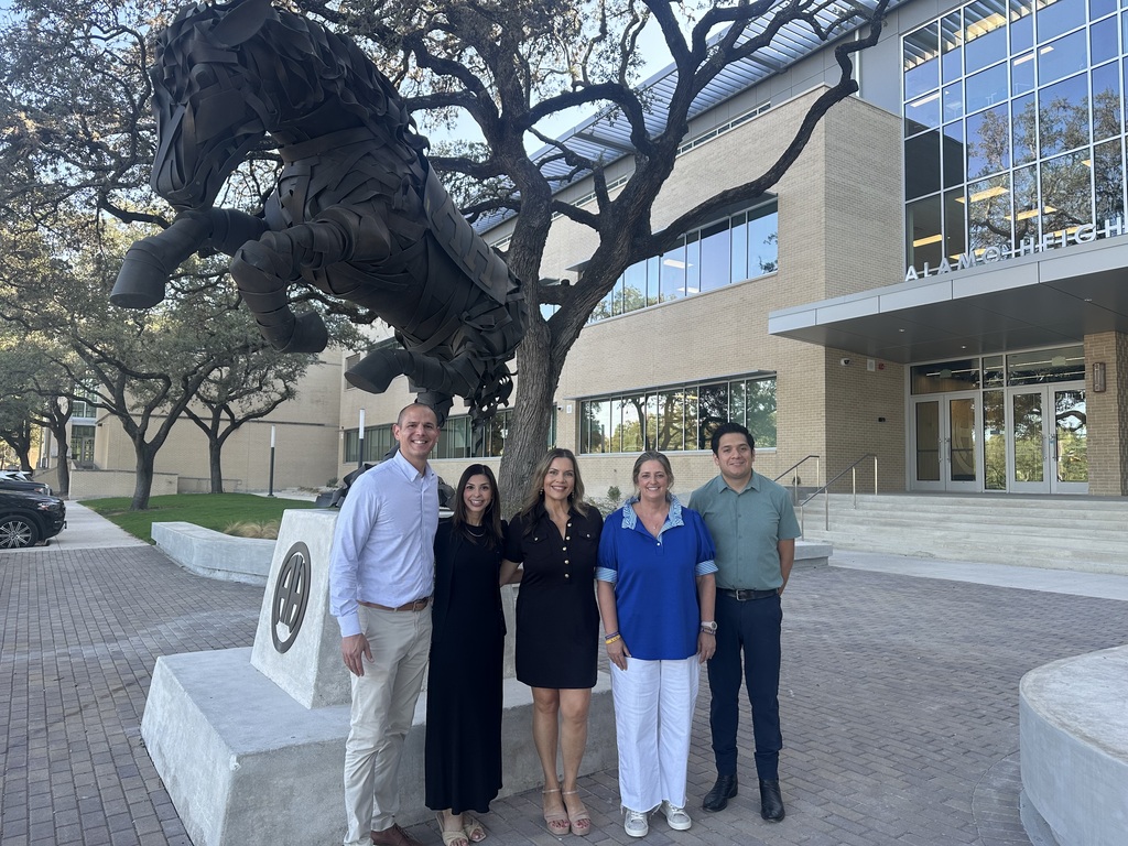 High school admin team poses in front of Mule statue