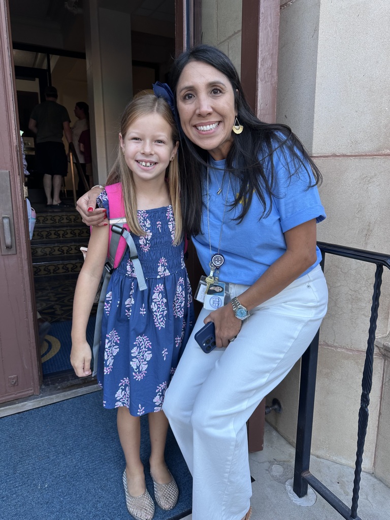 Principal and student pose outside school 