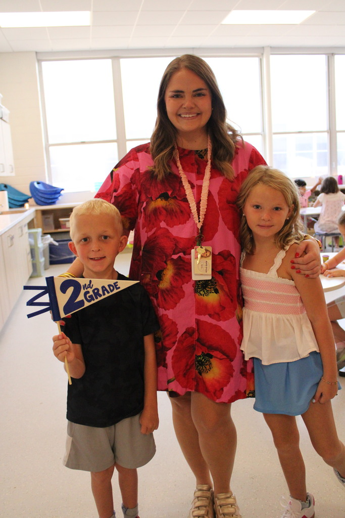 Teacher and two students pose in classroom door