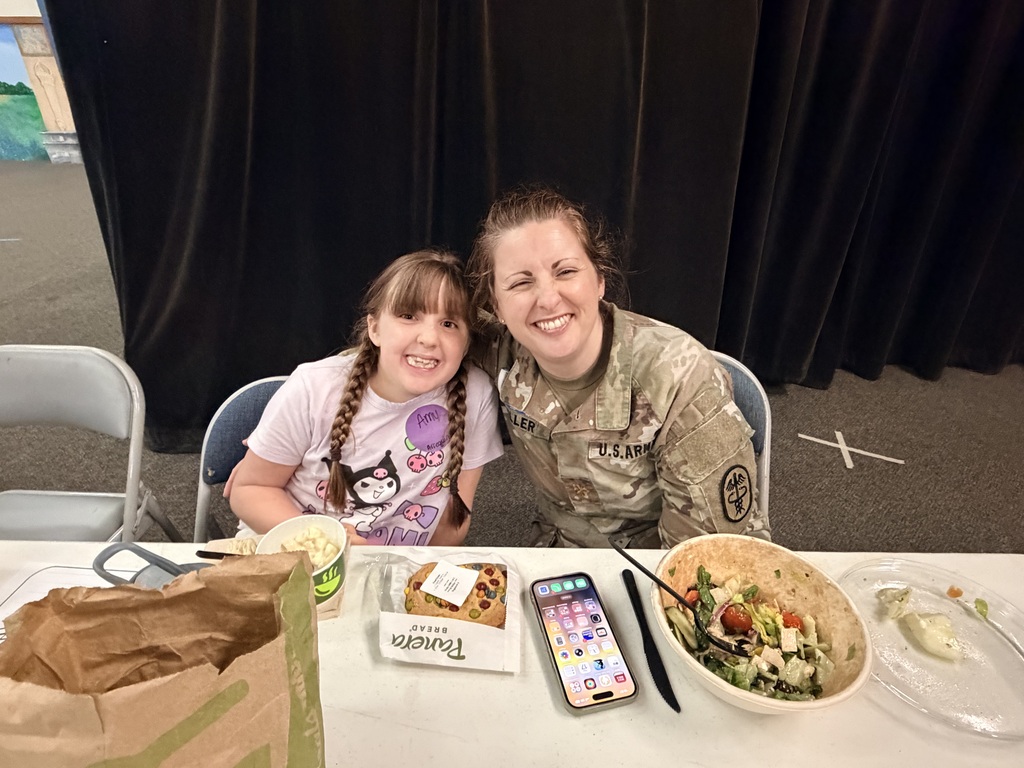 Mother in Army fatigues eating lunch with daughter