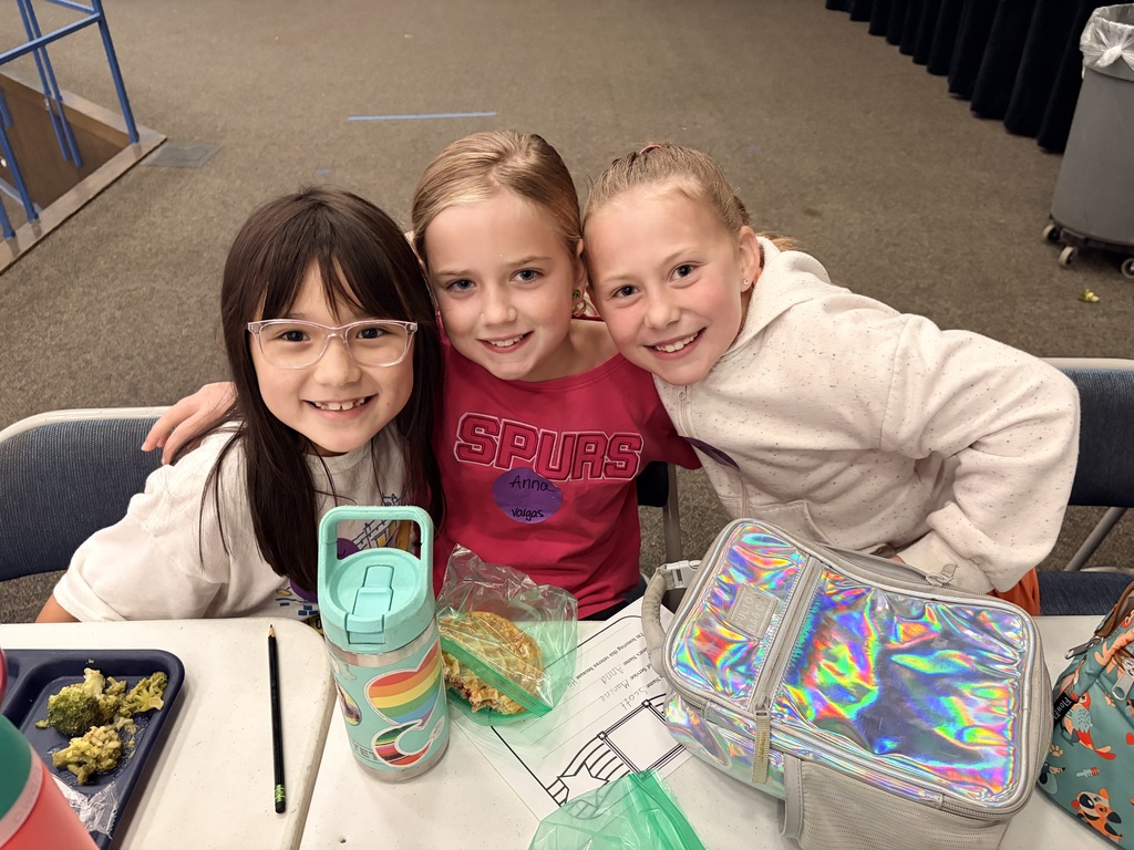Three girls pose for picture during lunch