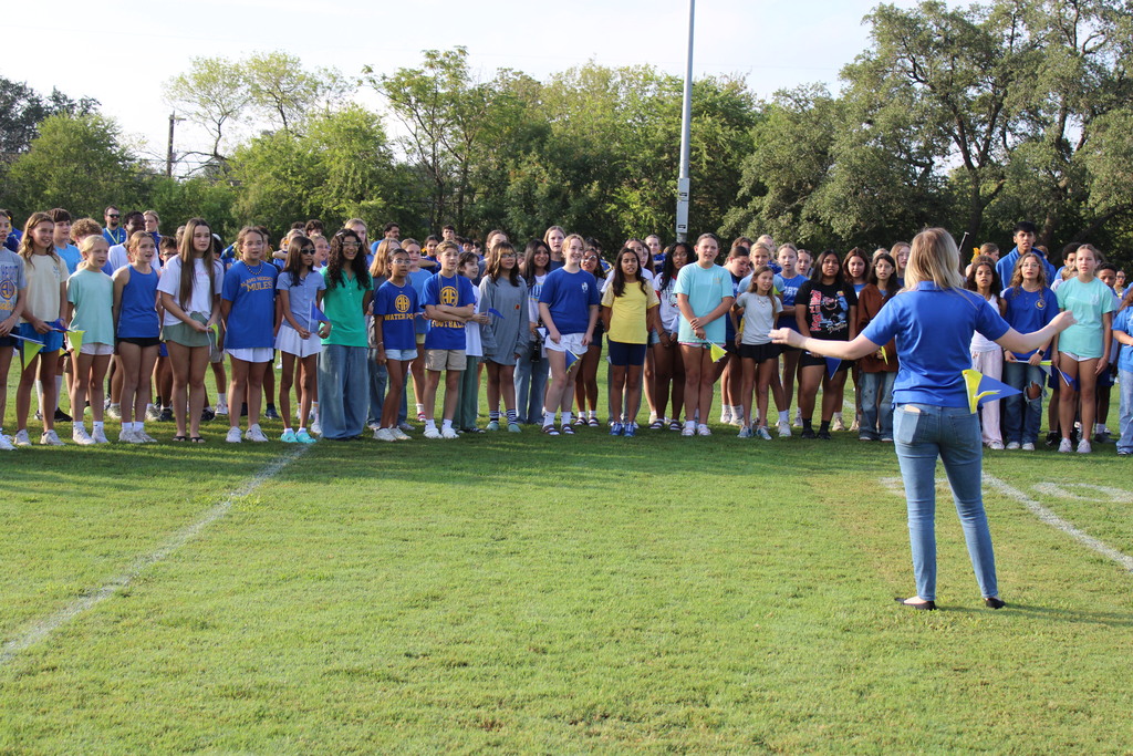 Choir sings on football field during pep rally