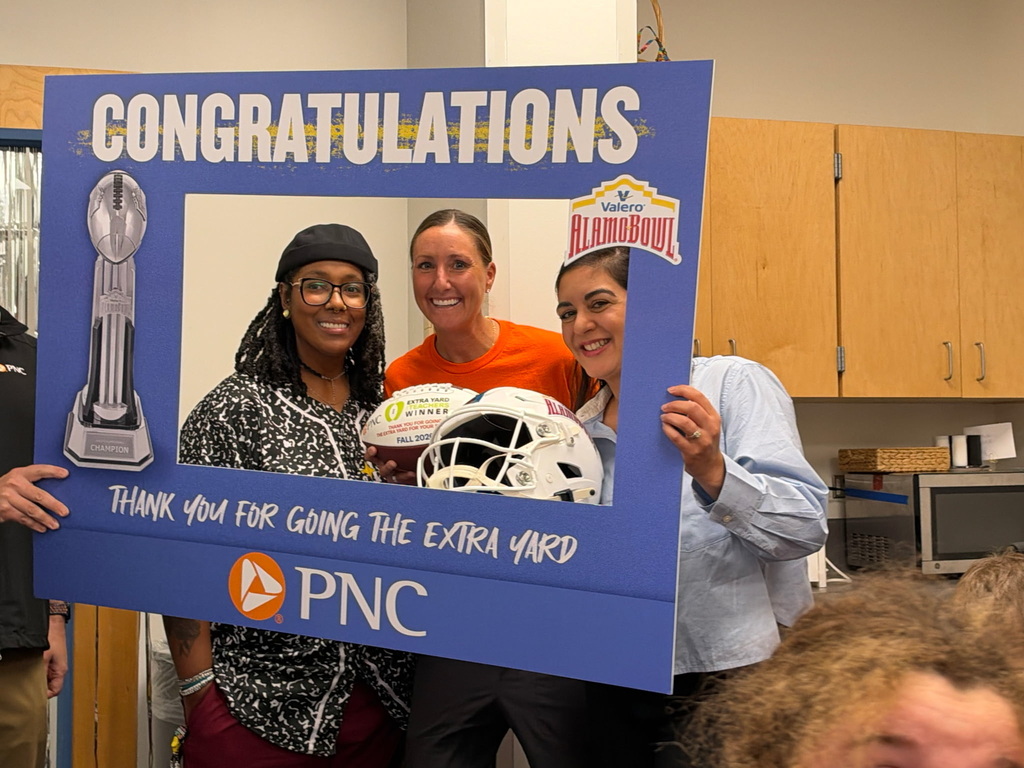 Woodridge team poses with Extra Yard sign