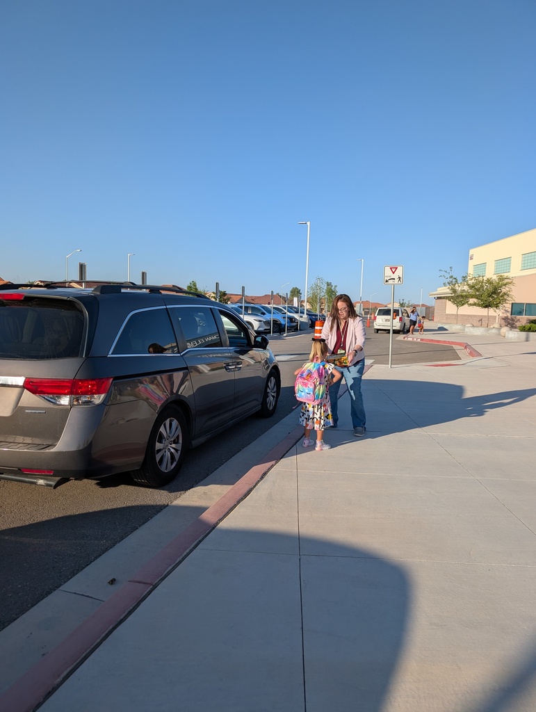 Teacher helping parent with school drop off.