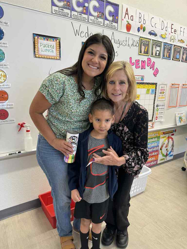 student in front of two teachers. One of them is their parent.