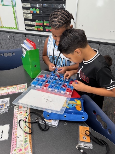 Two students working with magnetic letters