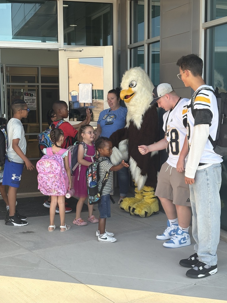 elementary school students greeting football players