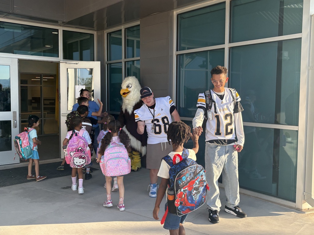 football players greeting elementary school students