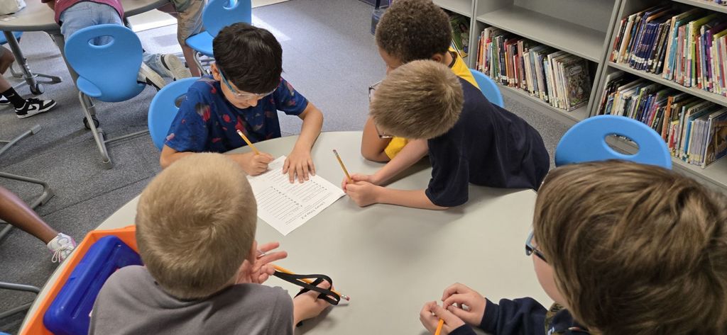 Students gathered around a table in a library working together