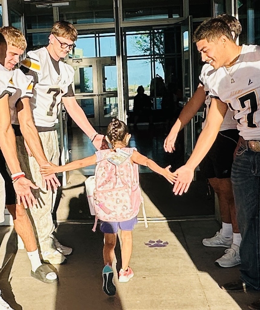 Alamogordo Tigers Football Team giving high fives to Desert Star kids.