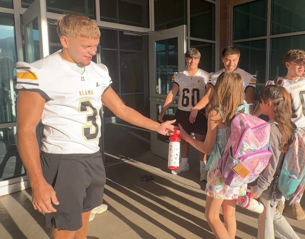 Alamogordo Tigers Football Team giving high fives to Desert Star kids.