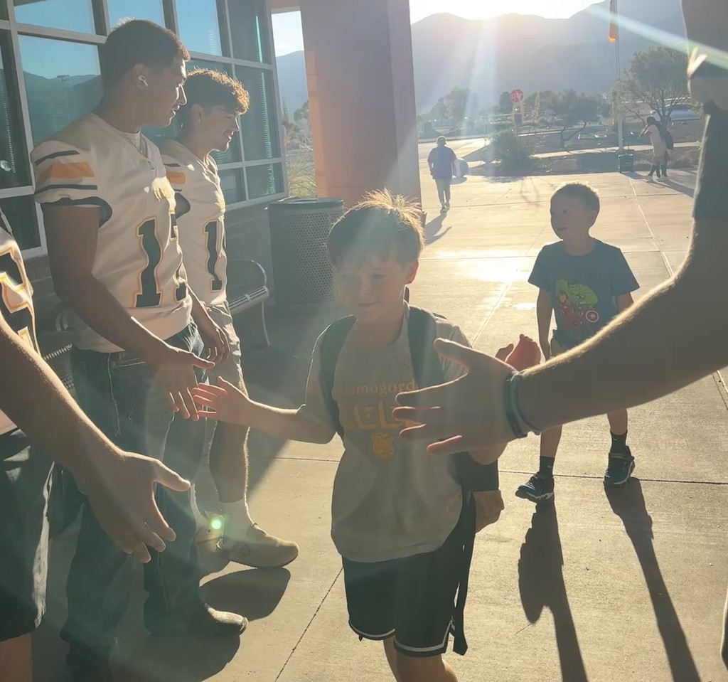 Alamogordo Tigers Football Team giving high fives to Desert Star kids.