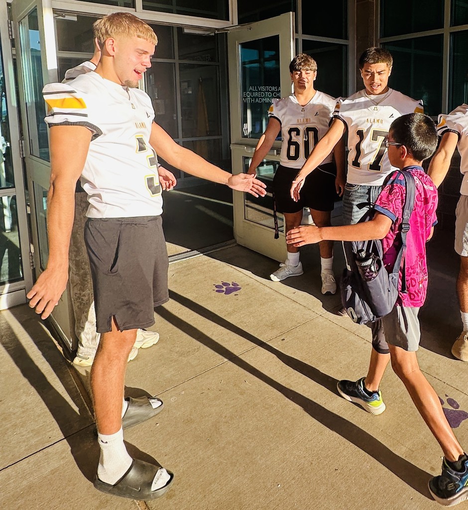 Alamogordo Tigers Football Team giving high fives to Desert Star kids.