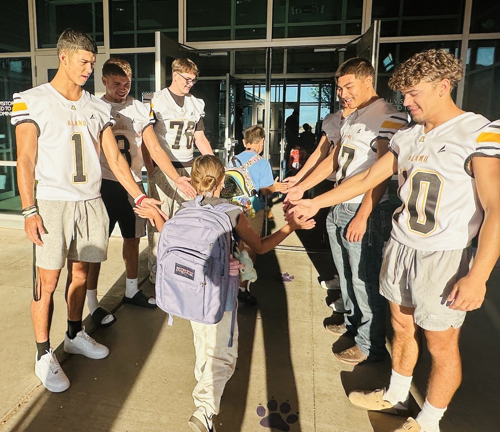 Alamogordo Tigers Football Team giving high fives to Desert Star kids.
