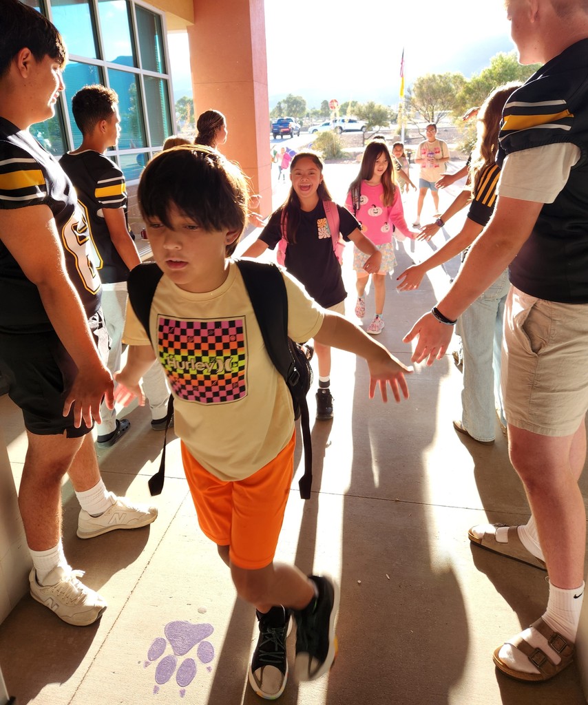 AHS Tigers Football team high-fiving Desert Star Elementary Students