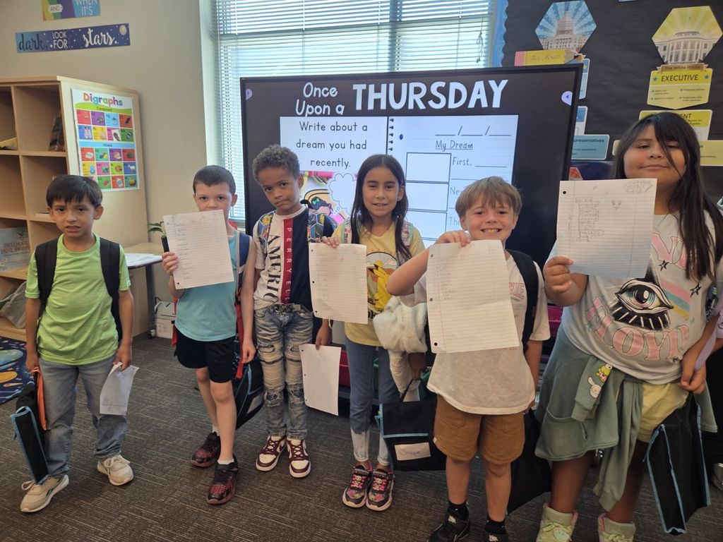 3rd grade students showing off their earned 100% on the VC/CV spelling pattern test,