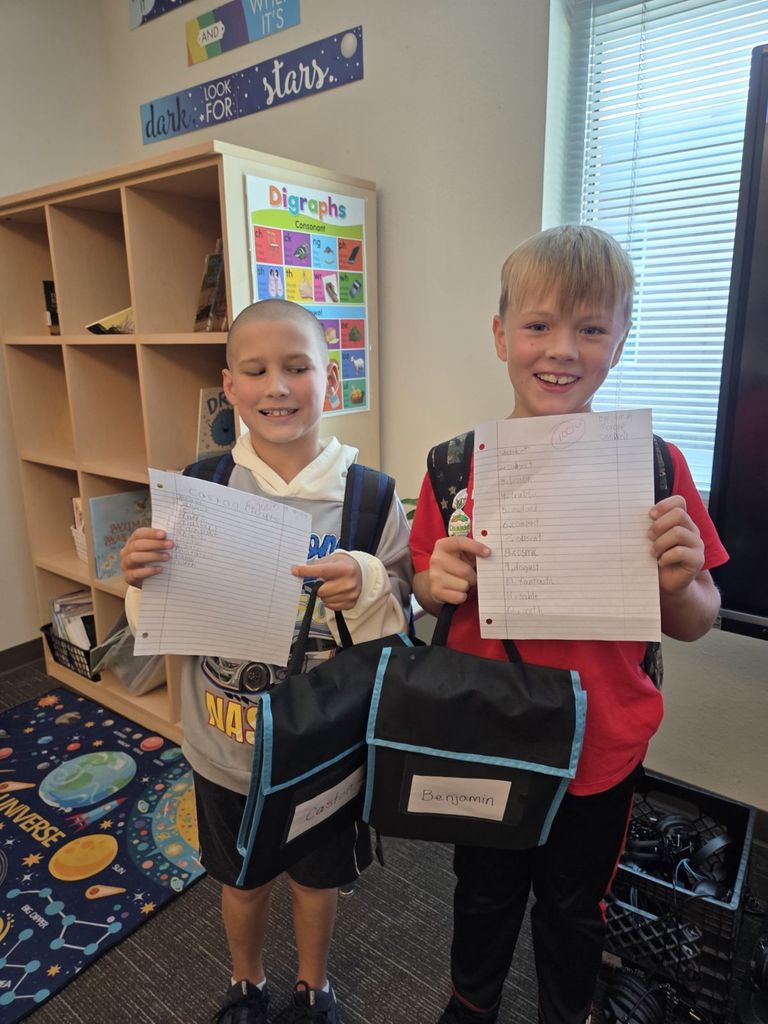 3rd grade students showing off their earned 100% on the VC/CV spelling pattern test,