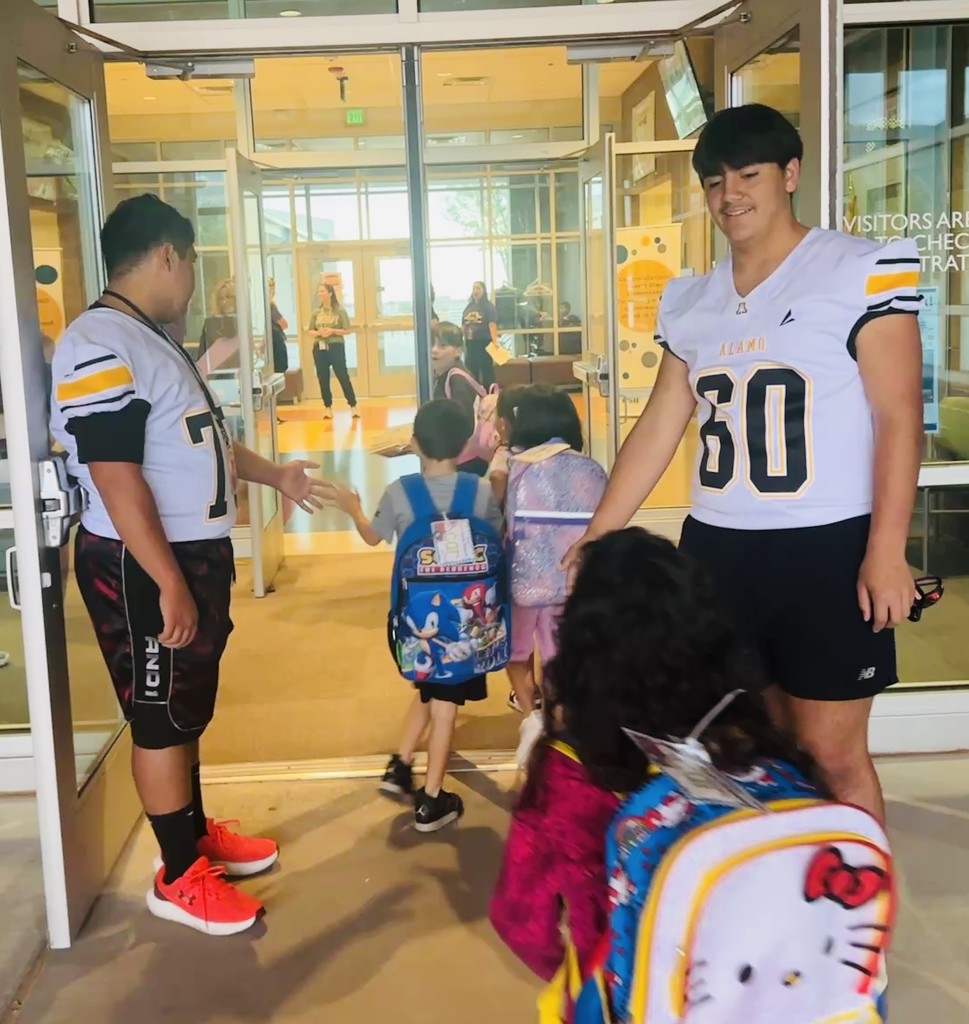 Alamogordo Tigers Football Team giving high fives to Desert Star kids.