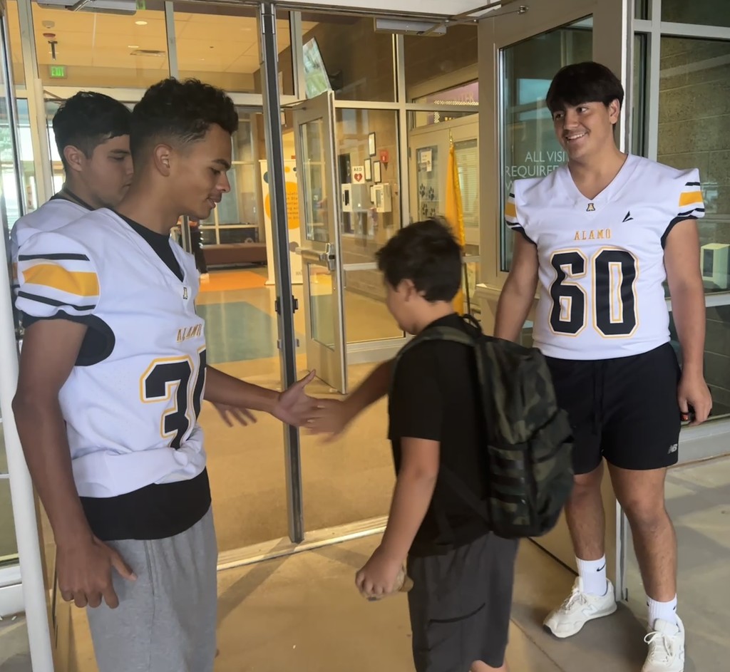 Alamogordo Tigers Football Team giving high fives to Desert Star kids.